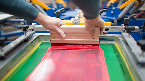 Silk screen press pulling red ink